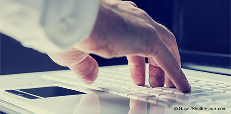 Image of male hand typing on a laptop keyboard