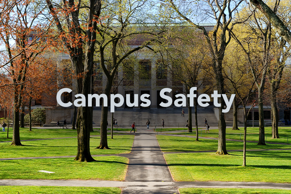 Campus Safety written on background of campus building behind trees