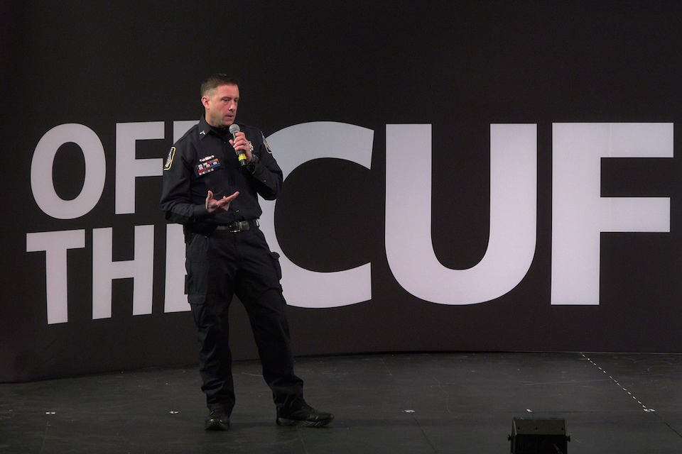 Policeman on stage talking in a microphone