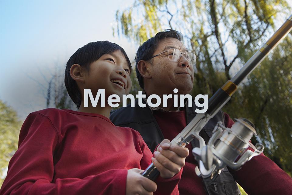 Mentoring on background of boy fishing with older man