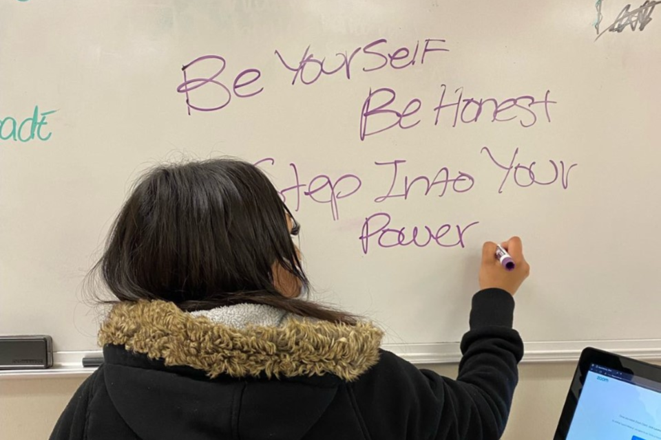 person in hooded sweatshirt writes on white board. Text reads: Be yourself. Be Honest. Step Into Your Power.
